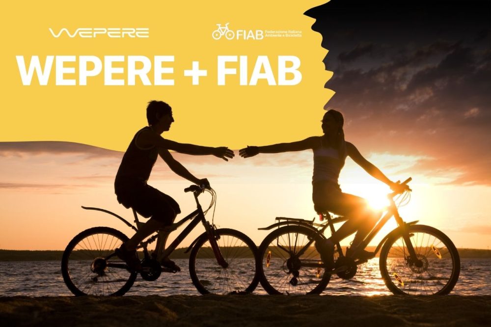 Due ciclisti in silhouette al tramonto con i loghi Wepere e FIAB, a rappresentare la partnership per il benessere e il cicloturismo.