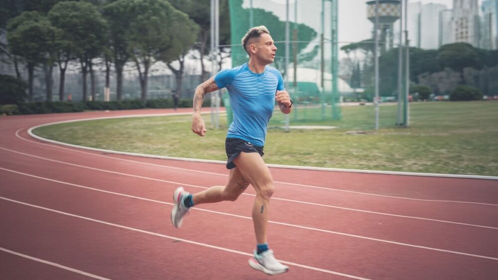 Lorenzo Lotti in piena falcata durante un allenamento di podismo su pista d'atletica, ambassador per il recupero avanzato WEPERE